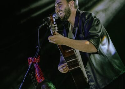 Blas Menchén cantando con la guitarra iluminado por un foco