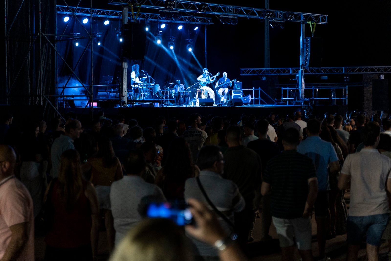 Público viendo un concierto de Grupo Kalanda en una plaza por la noche