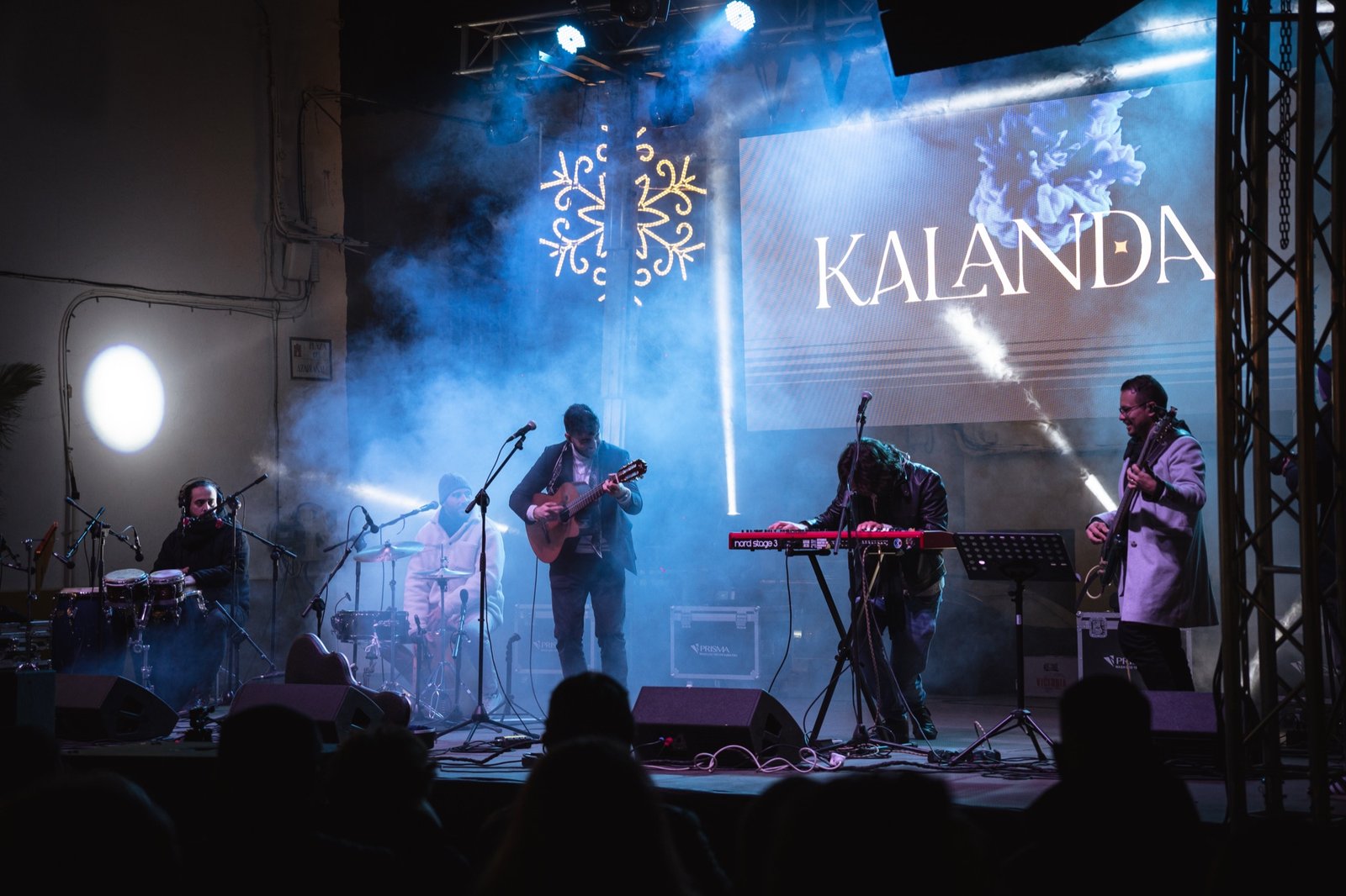 Grupo Kalanda en concierto con el logo KALANDA en la pantalla