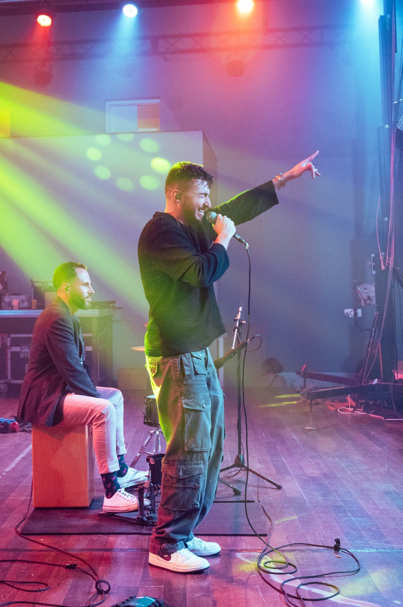 Blas Menchén cantando con el micrófono en la mano y un percusionista al cajón