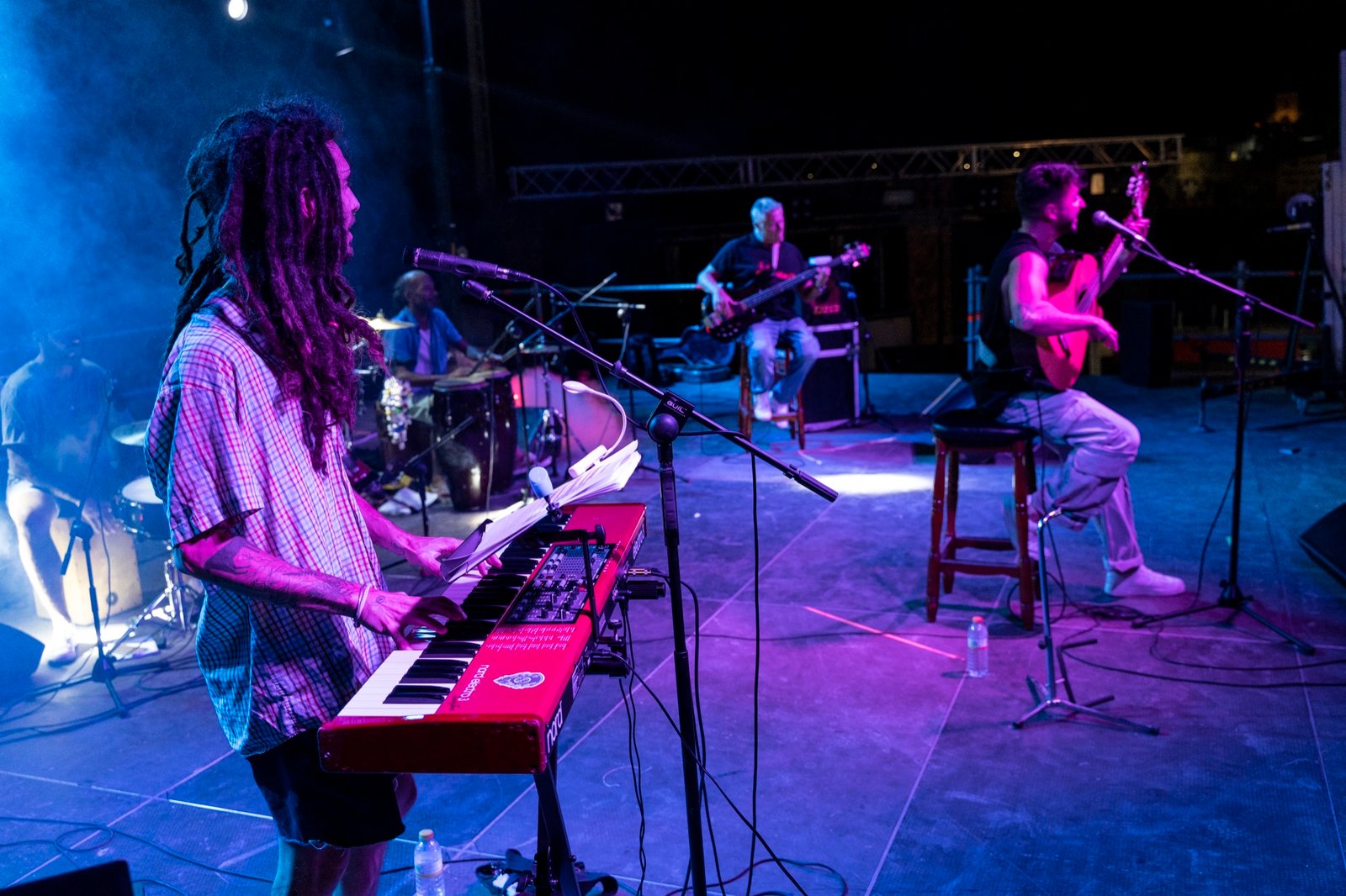 Teclista y grupo de Kalanda tocando en directo con luces moradas