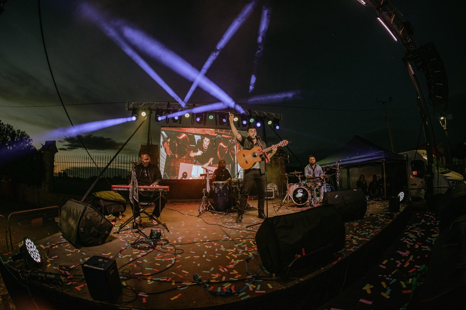 Grupo Kalanda en concierto al anochecer con focos y confeti