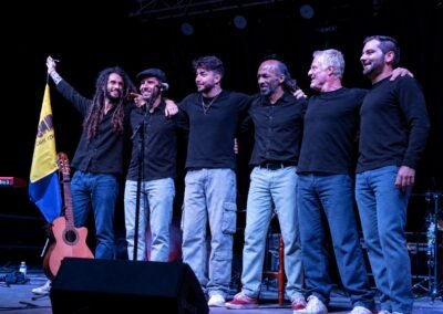 Músicos de Grupo Kalanda saludando abrazados al final de un concierto