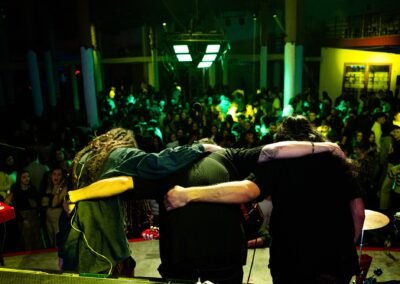 Grupo Kalanda abrazados de espaldas frente al público en una sala de conciertos