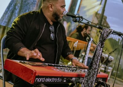 Pianista de Grupo Kalanda tocando el teclado en un evento al aire libre